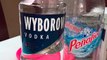 presentando una botella de vodka wyborowa con agua mineral de manantial