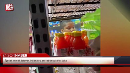 İçecek almak isteyen insanlara su tabancasıyla şaka