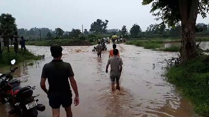 जान जोखिम में डालकर उफनते नाले को पार कर रहे राहगीर