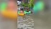 Light-hearted locals play in boats on flooded road after typhoon Doksuri hits Philippines