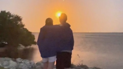 Couple's excitement shoots up to the sky when they both take out rings to propose while watching a lit rocket launch