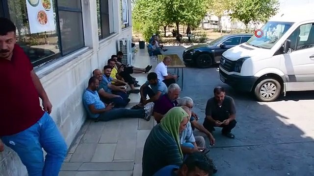 Les conducteurs qui attendent dans le parc à camions de Şırnak se rafraîchissent à l'ombre de leurs véhicules