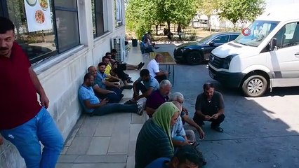 Les conducteurs qui attendent dans le parc à camions de Şırnak se rafraîchissent à l'ombre de leurs véhicules