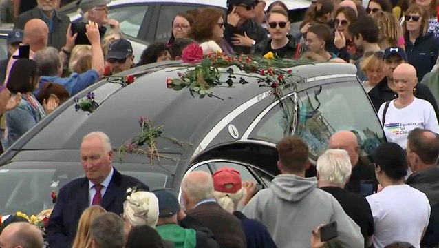 Sinead O’Connor’s funeral procession travels through singer’s hometown as thousands of mourners line streets