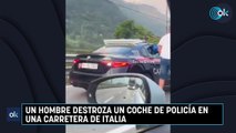 Un hombre destroza un coche de policía en una carretera de Italia
