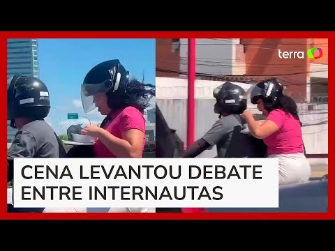 Mulher é flagrada comendo marmita na garupa de moto, e vídeo viraliza nas redes sociais