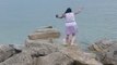 Woman Walking on Rocks Loses Footing and Falls Into Water