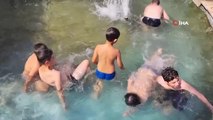 Sıcaktan bunalan çocuklar süs havuzuna girerek serinledi
