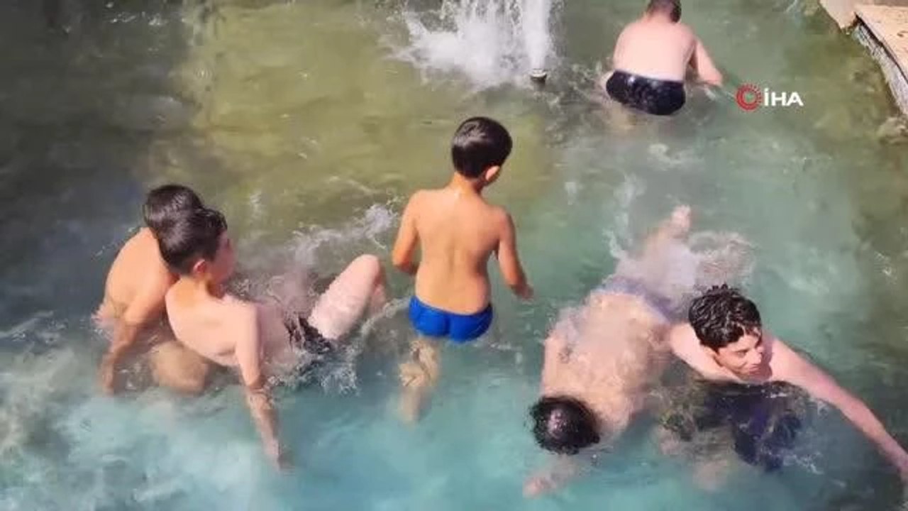 Sıcaktan bunalan çocuklar süs havuzuna girerek serinledi