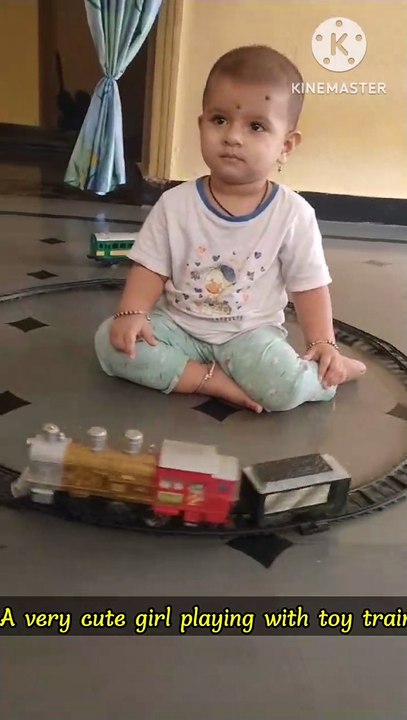 Very cute girl playing with toy train 