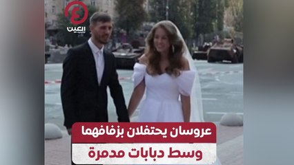 عروسان يحتفلان بزفافهما وسط دبابات مدمرة