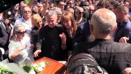 L'uscita del feretro dalla chiesa e l'omaggio musicale della folla