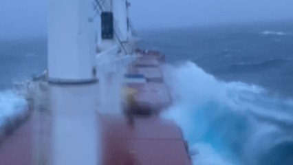 Challenging waves from the Atlantic Ocean breach the deck of cargo ship