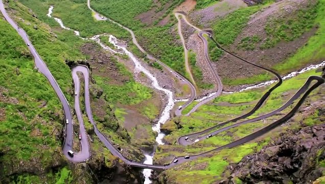 Il descend une route de montagne à l'envers sur son vélo