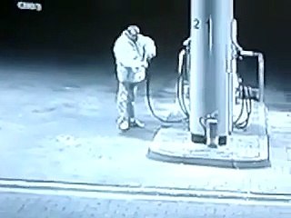 Un homme boit de l'essence à le pompe
