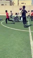 معلم سعودي يساعد طالباً ذو إعاقة في مباراة لكرة القدم