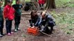 Prince William chops wood and Kate hides in a den as they join school children getting back to nature