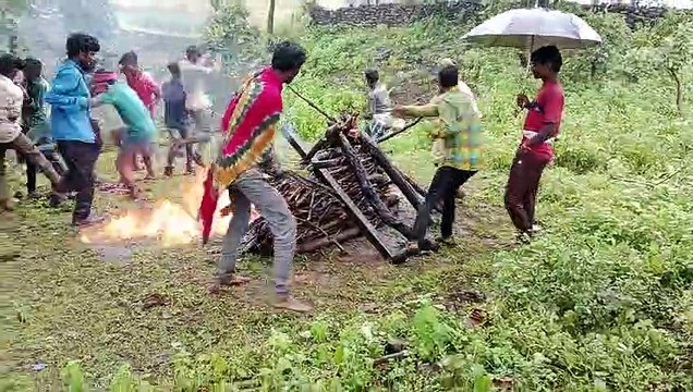 Pyre decorated under umbrella, cremation done by pouring petrol
