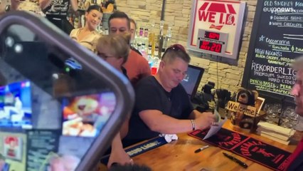 شاهد: ترامب يوزع البيتزا ويوقع على قميص إحدى النادلات في حانة بولاية آيوا