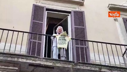 Beppe Grillo mostra una maglietta dal balcone della sede romana del Movimento 5 Stelle