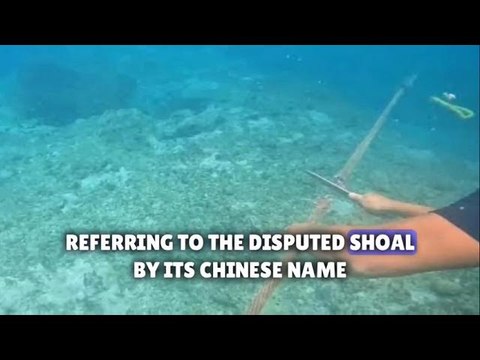 Filipino diver with a knife helps remove floating barrier installed by China in South China Sea