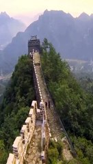 Two bricklayers demolish the great wall of china with an excavator
