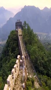 Two bricklayers demolish the great wall of china with an excavator