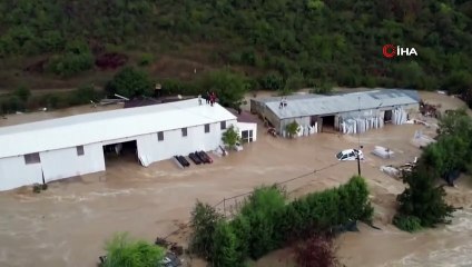 Les travailleurs qui ont sauvé leur vie en grimpant sur le toit pour se protéger du débordement du ruisseau à Istanbul attendent l'assistance d'un hélicoptère.