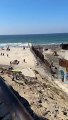 Des migrants et des chiens errants traversent la barrière frontalière ouverte entre les États-Unis et le Mexique à Tijuana