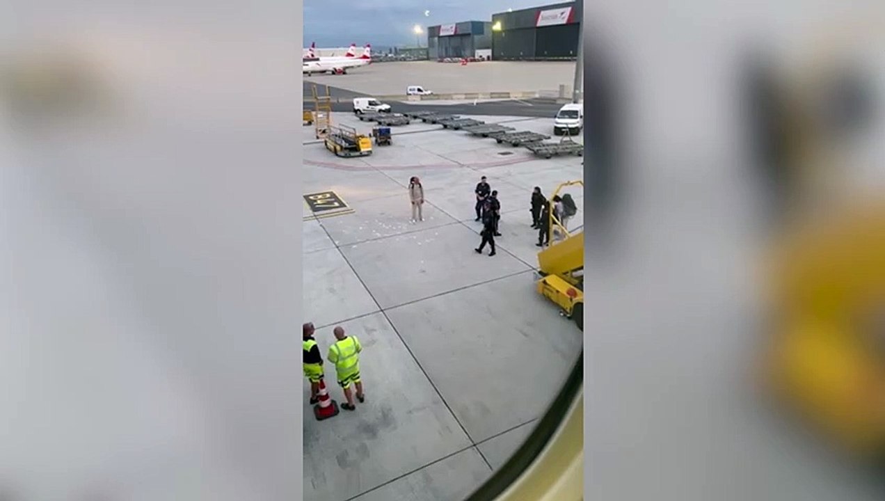 Passengers escorted off plane: Woman throws ''£5,000 in cash'' at man on an airport runway