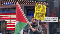 Fury as Palestinian protester waves a SWASTIKA at anti-Israel rally in New York City's Times Square as thousands of demonstrators take to the streets across the US - while rockets and gunfire flies in the Middle East