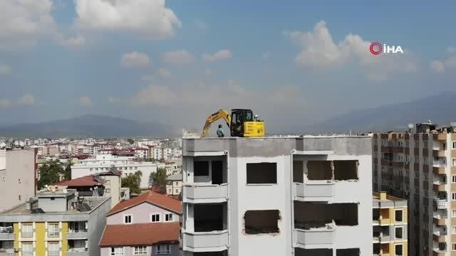 Ağır hasarlı binanın üzerine 10 tonluk iş makinesi çıkarıldı