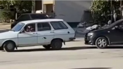 Arıza yapan otomobili, arkadaki otomobilin üzerine yatan çocukla ittiler