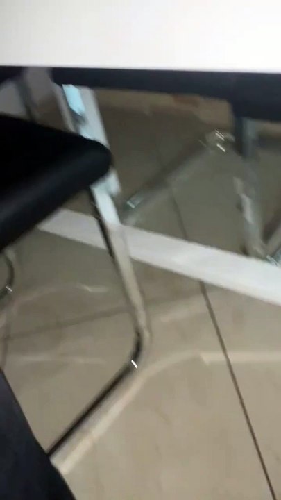 Un chaton araignée se cache sous la table de la cuisine