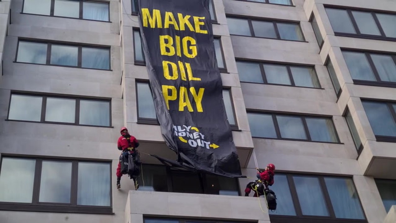 Climate activists abseil down luxury London hotel to unfurl oil protest banner