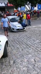 Mulher sobe em capô de carro em que marido estava com amante