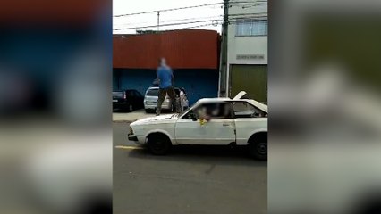 Homem é flagrado "surfando" em capô de carro no Coqueiral