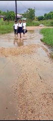 Alumnos y maestros caminan descalzos hasta el centro educativo por las lluvias