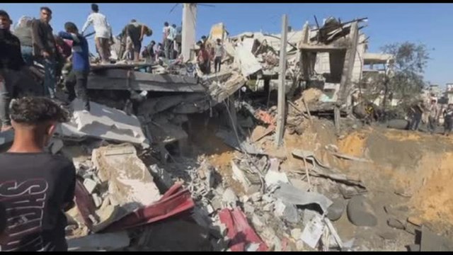 Palestinesi cercano sopravvissuti dopo l'attacco israeliano a Rafah