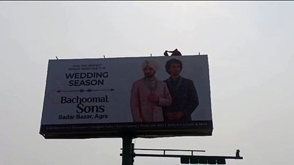 एडवरटाइजिंग पोल पर चढ़ी महिला, दो घंटे तक मिन्नतें करती रही पुलिस, वीडियो वायरल