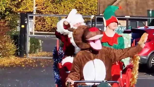 Father Christmas arrives on a motor mower to the surprise of school children