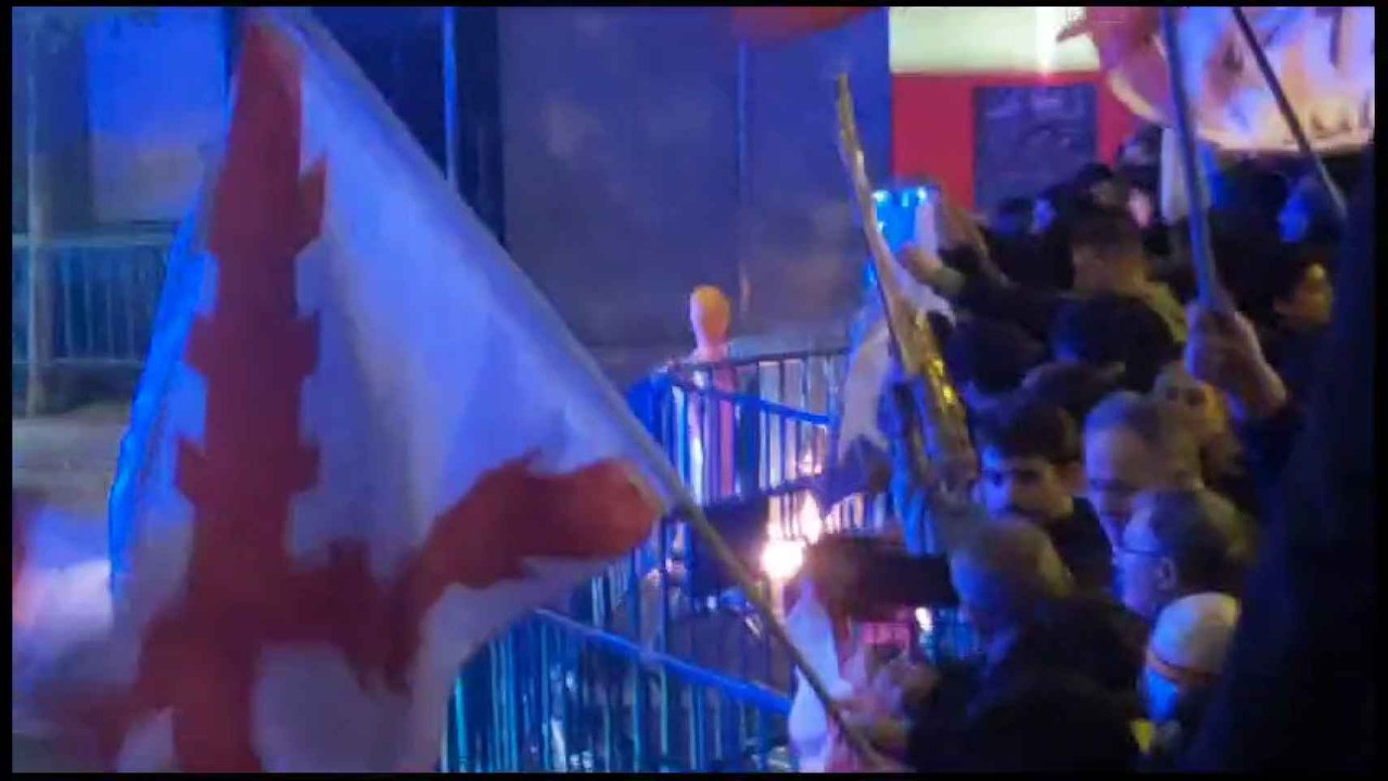 Manifestantes queman una bandera frente a la línea policial
