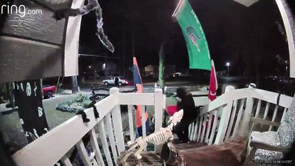 Un adulte semble voler un seau entier de bonbons sur le porche