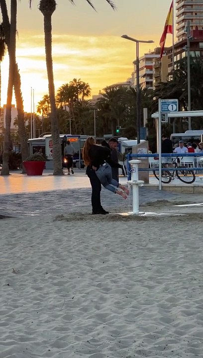 Man Helps His Girlfriend Avoid Sandy Feet