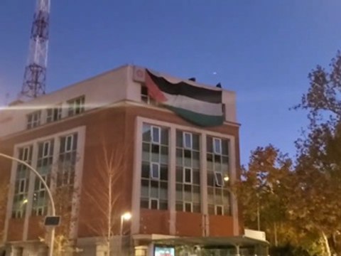 Una pancarta y la bandera Palestina frente a la embajada israelí en Madrid