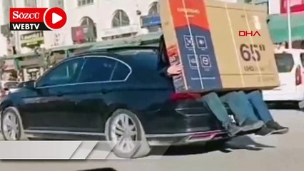 Video herunterladen: Yeni alınan televizyonu otomobilin bagajına oturan 2 kişi taşıdı