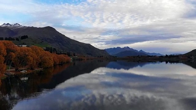 Beautiful Scenery of a Calm Lake Across the Mountains Under Cloudy Sky