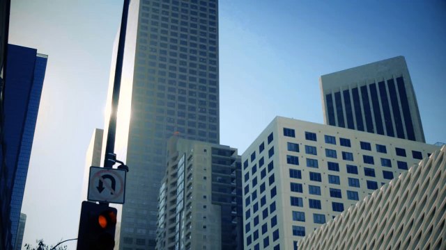 Vertical Panning Shot Of Traffic Lights And Street Sign At Downtown.