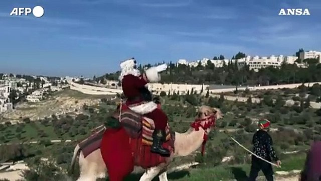 Israele, Babbo Natale sul cammello per le strade di Gerusalemme