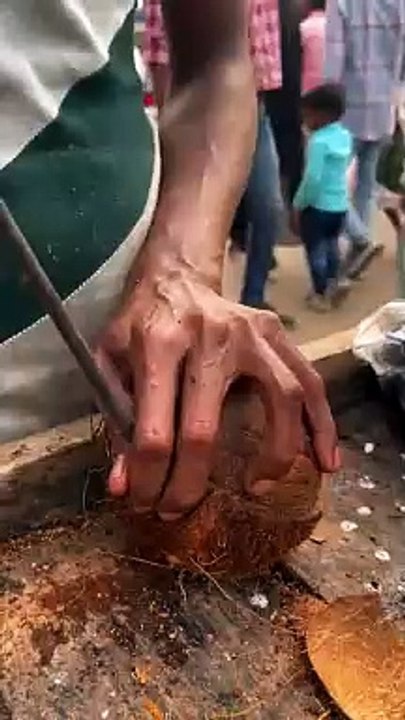 the uniqueness of Indian people peeling coconuts